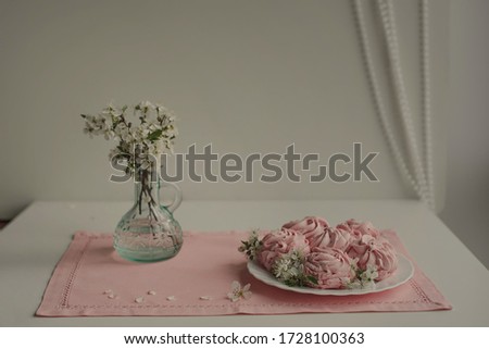 a vase of cherry blossoms and white marshmallows on a pink napkin . soft background for text. The spring layout. Invitational. Holiday . plenty of copy space