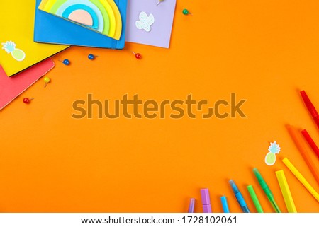 Back to school concept. Set of different school supplies, notebook, pen, accessories on orange paper textured background. Various scolorful stationery items. Close up, copy space, top view, flat lay.
