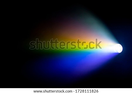 rainbow projector spotlight with light beam for movie and cinema at night on smoke texture .