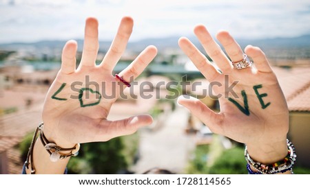 A picture of 2 hands with written 'Lo' one hand and 've' on another hand. 