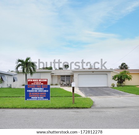Sold Real Estate Sign 'Another Success let us help you buy sell your next home' Suburban Ranch Style Two Car Garage Landscaped Home residential neighborhood blue sky clouds USA