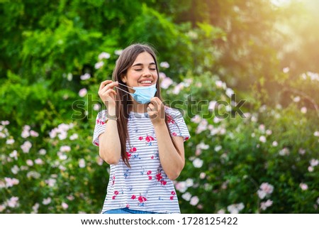 Quarantine is over concept. Woman taking off mask outdoor. We are safe. Coronavirus ended. We won. No more quarantine. Breathe deep. Take off the mask. Coronavirus is over Royalty-Free Stock Photo #1728125422