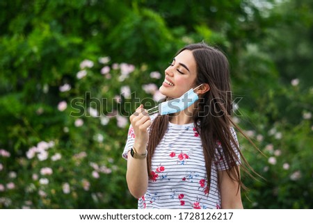 Quarantine is over, coronavirus is finish. Lockdown end inscription, Coronavirus Quarantine End, Pandemic Over. Young beautiful woman taking her mask off Royalty-Free Stock Photo #1728126217