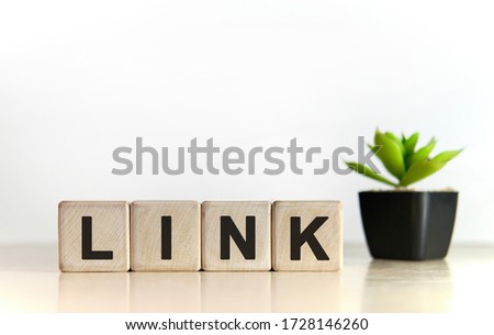 Link text on a white background. Wooden cubes and flower in a pot. Royalty-Free Stock Photo #1728146260