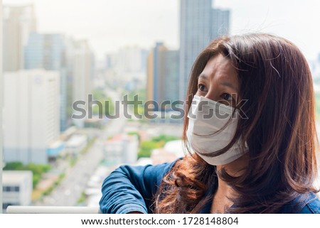 Stop the spread and Save lives campaign. Asian woman wearing  medical protective mask and Blurred city on background. The use of a mask against coronavirus. Hope concept