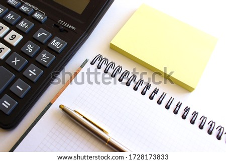 Calculator pen and notebook on white background