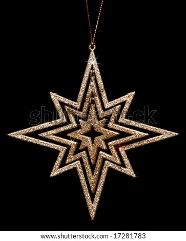 golden glitter christmas star decoration on black background
