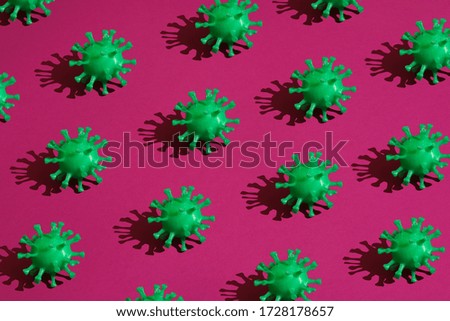 many green volumetric models of coronavirus with a hard shadow on a purple background. Concept pattern on the theme covid-19
