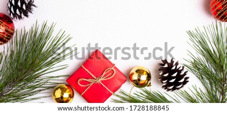 Background for the New Year, Christmas. Christmas toys and conifer branches. Gift in red paper, white cone. Place for text. Royalty-Free Stock Photo #1728188845