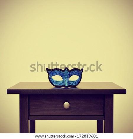 picture of a blue carnival mask on a desk, with a retro effect