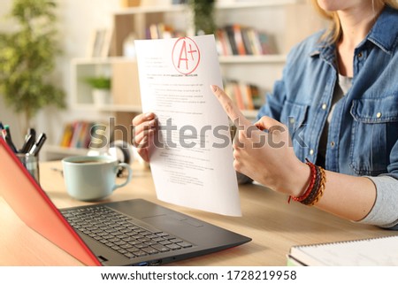 Close up of student girl hands showing passed exam on video call on a laptop webcam at home Royalty-Free Stock Photo #1728219958