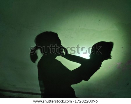the shadow of a mother playing with her daughter