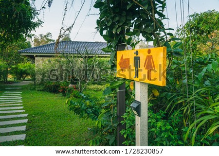 yellow wooden toilet entrance sign