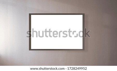 huge modern blank poster with space for template and dark frame hangs on light wall in conference hall