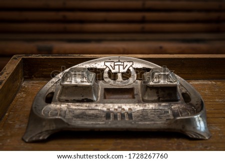 Closeup of a very old inkwell standing on a wooden table
