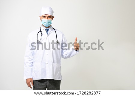 happy doctor in uniform and mouth protection, celebrating or showing victory sign against the virus or the illness