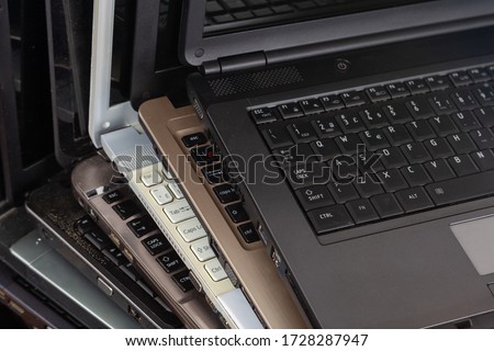 Stack of used laptops in different colors and models. Tha notebooks for repair and service. Royalty-Free Stock Photo #1728287947