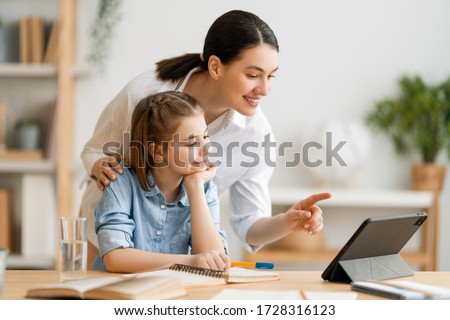 Back to school. Happy child and adult are sitting at desk. Girl doing homework or online education. Royalty-Free Stock Photo #1728316123