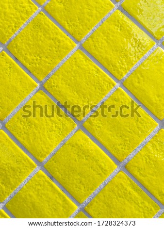 Yellow tiled wall pattern with textured glazed surface