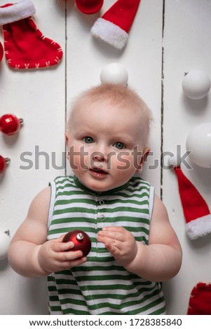 Overhead view of a baby celebrating christmas playing with festive decorations