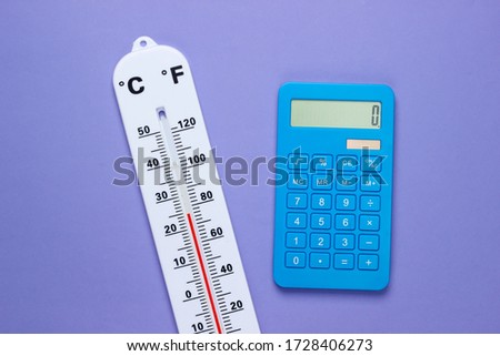 Global warming concept. Climate control. Weather thermometer and calculator on purple background. Top view.
