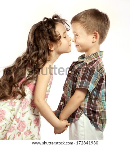 Littlt girl kisses a boy and holding his hands