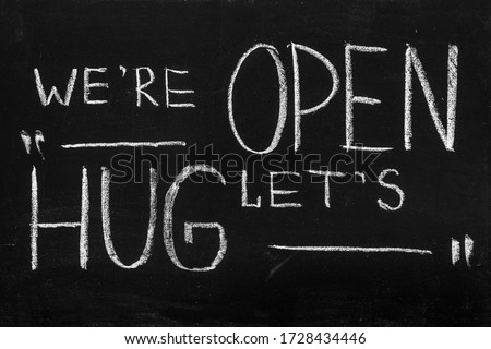 End of quarantine.Chalkboard text message We're open, let's hug