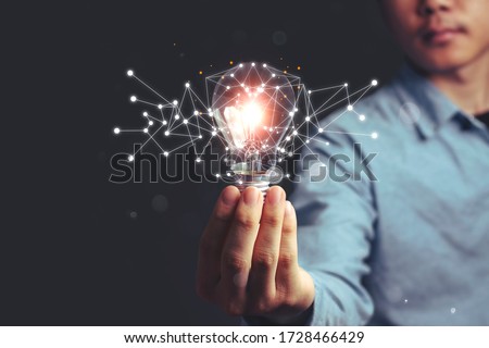 Asian Men holding light bulbs, ideas of new ideas with innovative technology and creativity. concept creativity, Branch with bulbs that shine glitter. Royalty-Free Stock Photo #1728466429