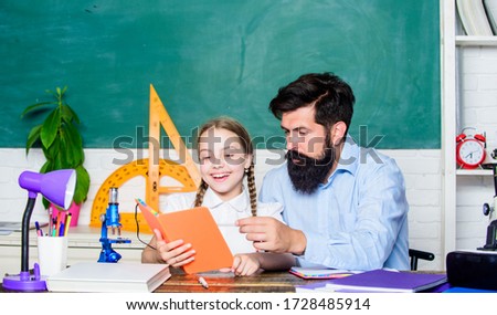 Childrens literature. math geometry. protractor ruler with setsquare. biology chemistry lesson. father and daughter study in classroom. bearded man teacher with small girl use book microscope.