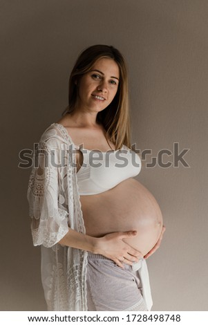 portrait of a pregnant woman,young pregnant girl gently touches belly,belly of a pregnant girl,clothes for pregnant women