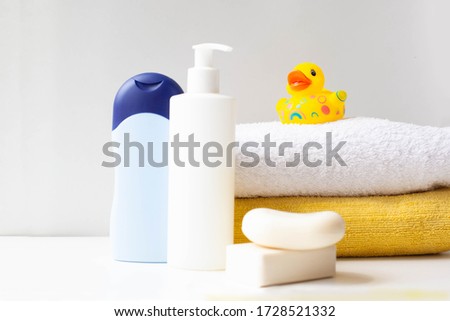 Baby accessories for bathing on table on light background. means for bathing the child. Baby Care, Shower Gel, Baby Shampoo, Rubber Duck, selective focus.