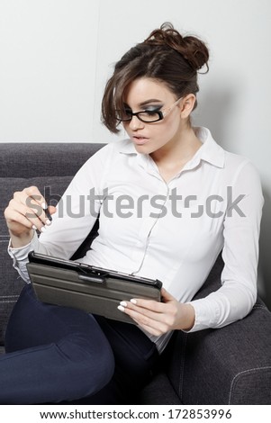 Businesswomen sitting on couch with digital tablet and studying at home 