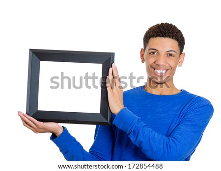Closeup portrait of happy smiling confident handsome man holding a rectangular square empty blank picture frame - Copy space provided. Positive emotion facial expression feelings