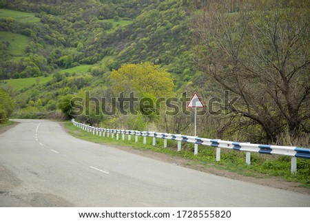 asphalt road and sign with green forest background