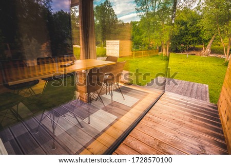 Modern wood house with patio and functional outdoor furniture with garden.