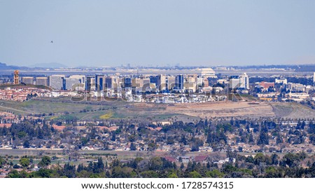 Aerial view of the San Jose downtown skyline on a clear day; residential neighborhoods visible in the foreground; south San Francisco bay, California
