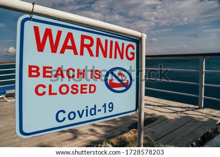 Beach is closed due to Covid-19 warning sign at the entrance to the beach. Social media campaign for coronavirus prevention. Vacation is cancelled, shutdown concept