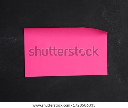 blank pink paper pink sticker glued on black chalkboard, place for inscription