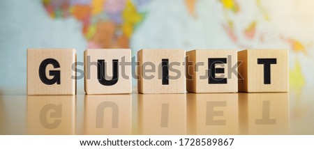 The word guiet symbol written on wooden cubes isolated on a political map background