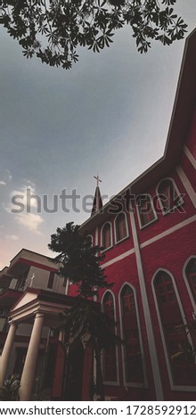 A wide angle picture of church. With the cross on top