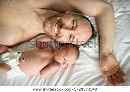 A nice father with a newborn baby in bed