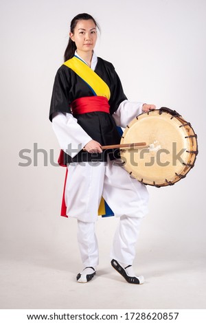 A girl in the national costume of Korea. Traditional musical instrument drum
