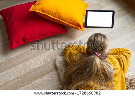 Girl reading a digital tablet on the floor 