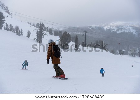 snowboarder enjoying skiing in mountains in the evening on the slope at winter ski resort Mammoth Lakes	