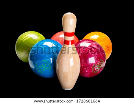 Wooden pin for bowling isolated on a black background. Bowling multi-colored ball.