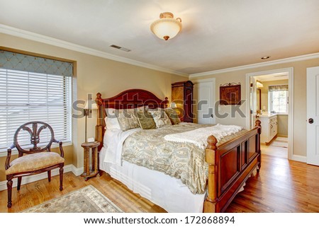 Large furnished bedroom with rustic antique furniture and hardwood floor
