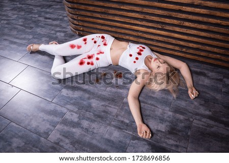 Crime scene (imitation). Pretty woman lying on the floor. She shot in the chest. 
