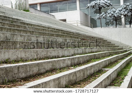 Close up to a Geometric pattern of a modern white street stairways with green grass, trees and nature architecture. 