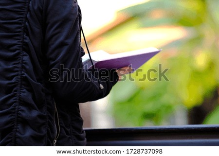 Man and woman writing a notebook and working in the park