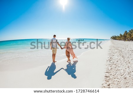 Romantic couple in love hugging, kissing and running on the sandy tropical Caribbean beach in Dominican republic landscape   Royalty-Free Stock Photo #1728746614